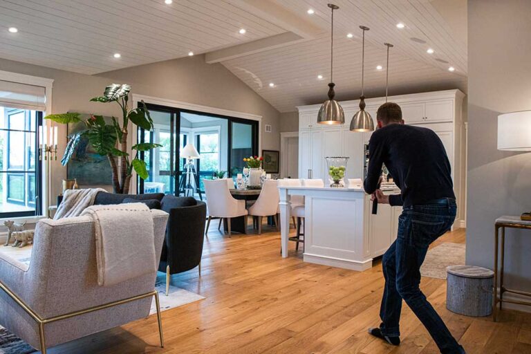 A prospective homebuyer checks for wall cracks and water stains inside a single-family home living room.